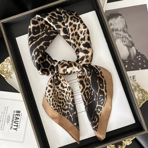 Detail of leopard print silk scarf with satin finish and elegant brown border trim