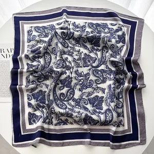 Détail macro du foulard en soie avec motifs paisley bleu marine et fleurs sur soie blanche