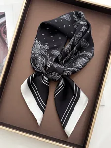 Detailansicht des schwarz-weißen Paisley-Musters und Saums auf dem Seidenhalstuch