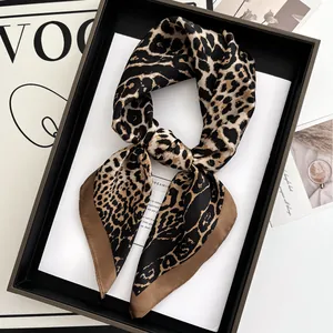 Detail of silk leopard print scarf with satin finish inside a black gift box