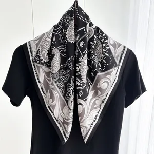 Dettaglio dell'elegante sciarpa in seta con stampa paisley in bianco e nero e bordi fini