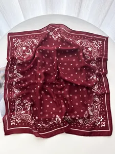 Detailed macro view of luxurious burgundy paisley silk scarf with herringbone texture