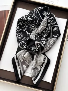 Dettaglio ravvicinato di un foulard in seta bianco e nero con motivi paisley annodato