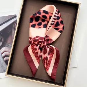 Detail of red and black leopard print satin scarf knot in a decorative tray