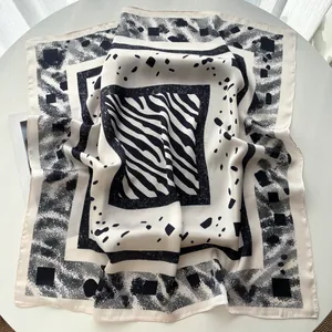 Detail of silk-texture square scarf with zebra and geometric patterns in black and white