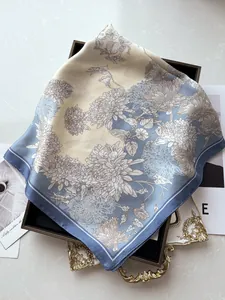 Detailed view of elegant blue floral silk scarf displayed on a marble tray