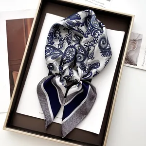 Détail d'un foulard en soie à motif paisley dans un coffret cadeau marron élégant