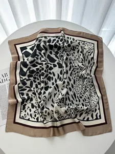 Dettaglio foulard in finta seta con stampa leopardata su espositore bianco minimalista