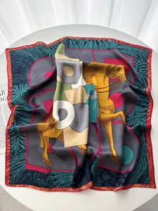 Detail of silk square scarf featuring horse patterns and colorful geometric designs on table