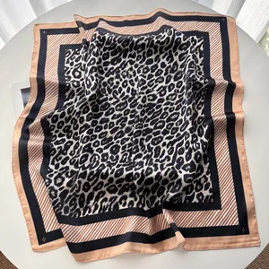 Detailed view of square silk scarf with leopard print and elegant striped borders