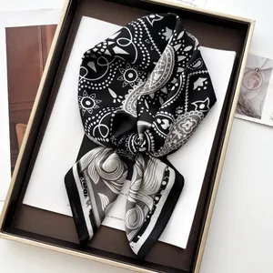 Elegante foulard in seta bianco e nero con motivo paisley su vassoio per outfit chic