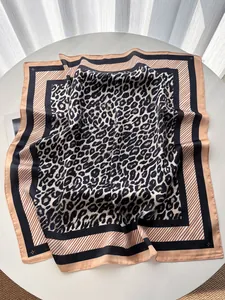 Détail d'un foulard en soie léopard avec des bordures géométriques bleu marine et beige chic