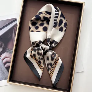 Detail of elegant leopard print silk scarf with black border on a vintage tray