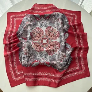 Detail of red and white paisley silk scarf showing smooth texture on a white table