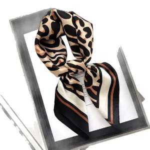 Leopard print silk scarf with black and gold geometric borders in a knotted style