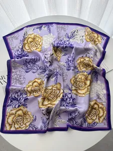 Detail of silk-like square scarf featuring elegant yellow peony print on purple fabric