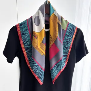 Detail of silk square scarf showing colorful leopard and palm leaf print on a hanger