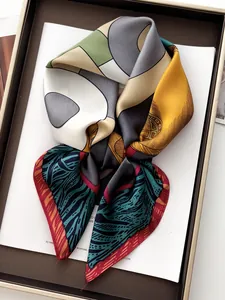 Detail of silk-texture square scarf with geometric patterns and satin finish on a display tray