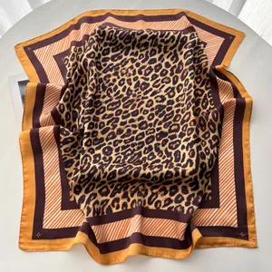 Détail d'un foulard en soie avec motif léopard et bordure géométrique élégante