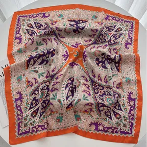 Detail of vibrant orange paisley silk square scarf with elegant geometric patterns