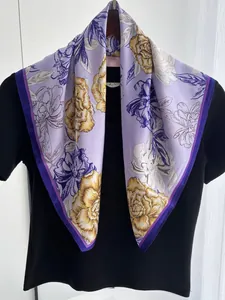 Detail of silk-like scarf with yellow floral prints and purple contrast border