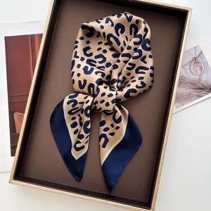 Dettaglio del foulard in raso di seta leopardato all'interno di una scatola regalo di lusso