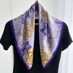 Detailed view of lavender silk scarf featuring vibrant yellow peony prints and purple borders