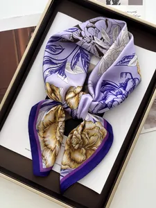 Macro view of lilac silk twilly scarf with floral print inside a premium gift box