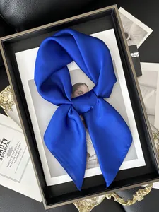 Gros plan d'un foulard en satin bleu roi avec texture soie brillante et détail noué
