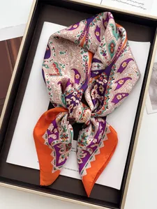 Detail of premium silk-like square scarf with paisley floral pattern and glossy finish