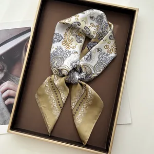 Detailed view of paisley silk scarf knotted elegantly on a decorative golden display tray