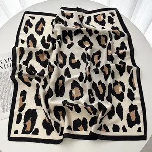 Dettaglio di un foulard quadrato in seta con stampa leopardata e bordo nero