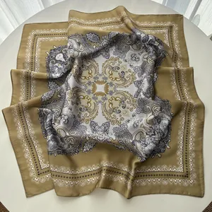 Detailed view of paisley silk scarf with gold and navy baroque patterns on satin fabric