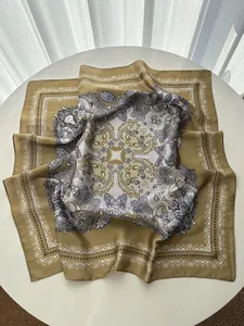 Detailed macro view of mustard yellow paisley and baroque pattern silk square scarf texture
