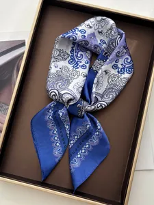 Detail of blue paisley print satin scarf featuring elegant floral patterns and silk texture