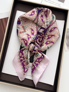 Detail of silk-like square scarf featuring classic paisley print in purple and orange