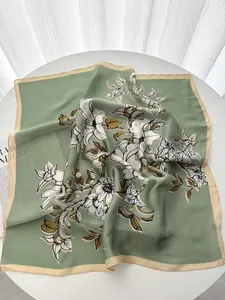 Detail of silk scarf with magnolia prints and beige edges on a refined table