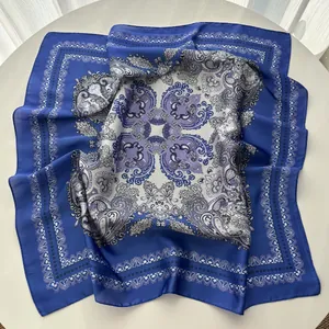 Close-up of royal blue paisley silk scarf showing soft texture and elegant patterns