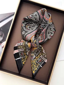 Close-up of elegant bohemian paisley satin scarf neatly folded in a premium gift box