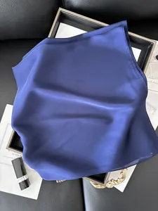 Gros plan d'un foulard en satin bleu roi élégamment posé sur un plateau noir