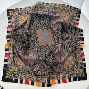 Detailed view of silk-like bohemian scarf with intricate paisley patterns on white surface
