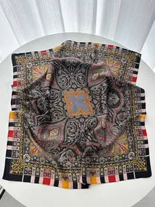 Detail of bohemian silk scarf with paisley patterns and striped borders on white surface