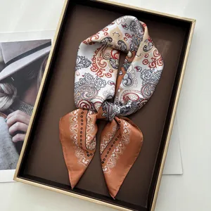 Elegant orange paisley silk scarf presented on a vintage display tray for women