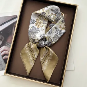 Elegant paisley print silk square scarf in gold and coffee tones displayed in a gift box
