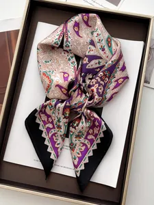 Detail of satin paisley scarf with vibrant purple and orange patterns in a gift box