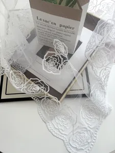 Macro detail of elegant white lace fabric with intricate camellia flower embroidery patterns