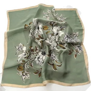 Elegant green square silk scarf featuring white magnolia floral prints and soft borders