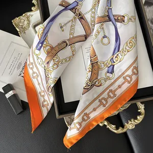 Detail of silk scarf featuring gold chain and equestrian patterns on a luxury background