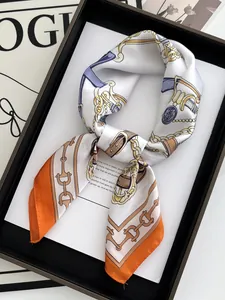 Close-up of silk square scarf with chain and belt prints tied in an elegant knot