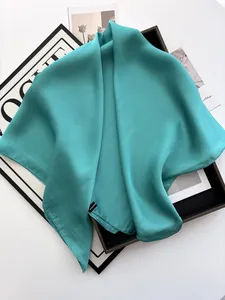 Vue détaillée du foulard en satin bleu sarcelle avec étiquette 100% polyester